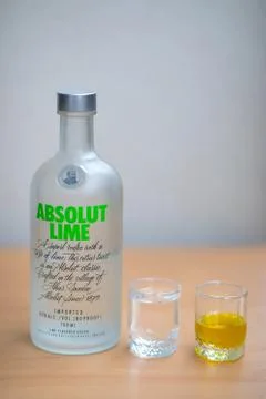 A bottle Absolut Vodka, one small glass Absolut Vodka and oil Stock Photos