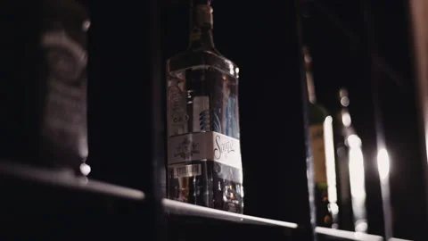 Bottle of alcohol is on the shelf in the bar Stock Footage 144003070