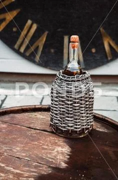 A bottle of alcohol. wicker decanter. watch for decoration. barrel of wood Stock Photos
