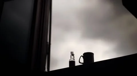 Bottle and a cup of coffee on a window. Dolly shot. Stock Footage 68521639