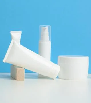 Bottle and empty white plastic tubes for cosmetics on a white background. P.. Stock Photos