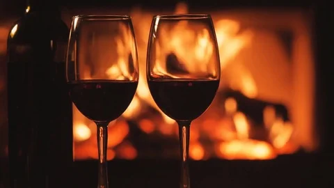 Bottle and two red wine  wineglasses over fireplace background. Stock Footage 82542185