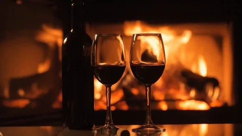 Bottle and two red wine  wineglasses over fireplace background. Stock Footage 82542729