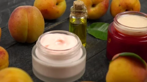 Bottle with apricot kernel oil and jars with cosmetic cream,  slow motion Stock Footage 278038513