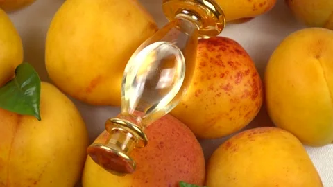 Bottle with apricot kernel oil placed on the fresh apricot fruit, background Stock Footage 278038811