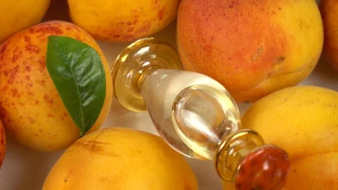 Bottle with apricot kernel oil placed on the fresh apricot fruit, background Stock Footage 278038832