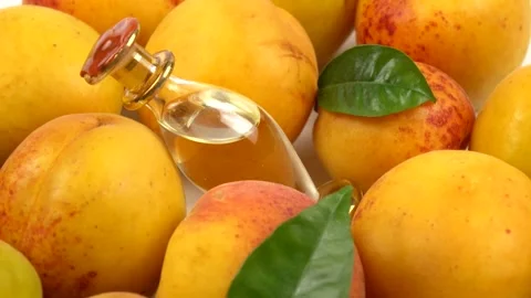 Bottle with apricot kernel oil placed on the fresh apricot fruit, background Stock Footage 278038867