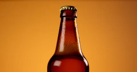 Bottle of beer with drops rotating in slow motion. Close up view, shot on RED 6K Stock Footage 107521327
