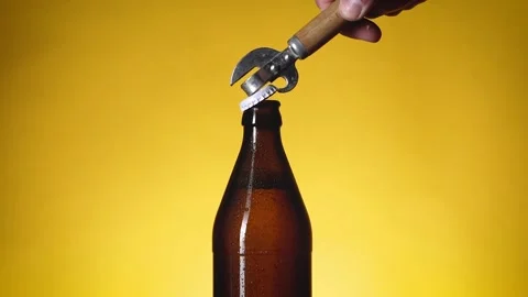 A bottle of beer is opened with an iron bottle opener. Stock Footage 196887443
