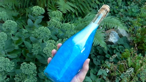 Bottle blue Elixir in hand Stock Footage 93902054