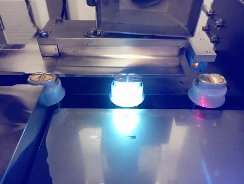 The bottle cap is being numbered by a laser Foto stock