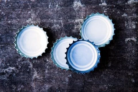 Bottle caps on rustic wooden table Stock Photos