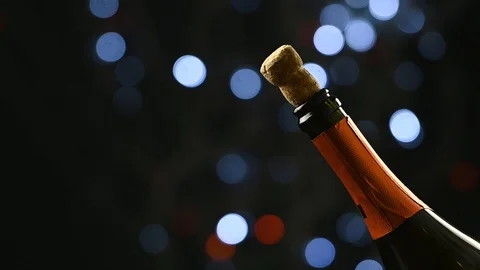 A bottle of champagne has opened and sizzles against the backdrop of the night's Stock Footage 126244986