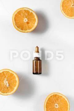 Bottle citrus essential oil and fresh juicy orange fruit on white background Stock Photos