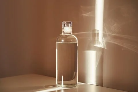 A bottle of clean drinking water in a ray of morning sun. Stock Photos