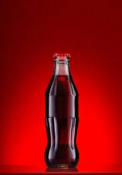 Bottle of cola on red background Stock Photos