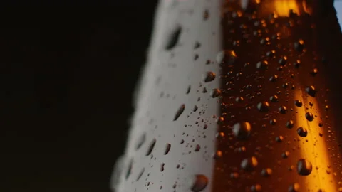 A bottle of cold beer on a black background. A drop flows down from the bottle. Stock Footage 146126381
