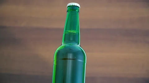 A bottle of cold beer on a brown background. Rotation 360 degrees Stock Footage 135999996