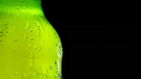 A bottle of cold beer slowly rotates against a dark background. Cold light beer Video stock 153515584