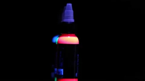 Bottle contains reflective paint, backlight, for tattooing on the skin, with bla Stock Footage 196099392