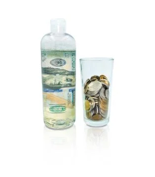A bottle with dollar bill inside and a glass of coins standing next to it Stock Photos