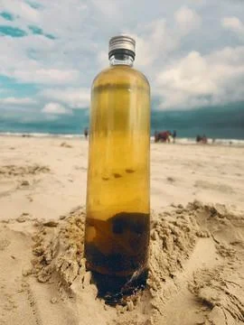 Bottle of drink on the sand Stock Photos