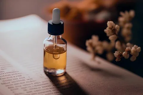Bottle with a dropper on the background of old handwriting, book. Natural medici Stock Photos