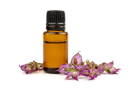 A bottle of essential oil with fresh blooming clary sage twigs on white backg Foto stock
