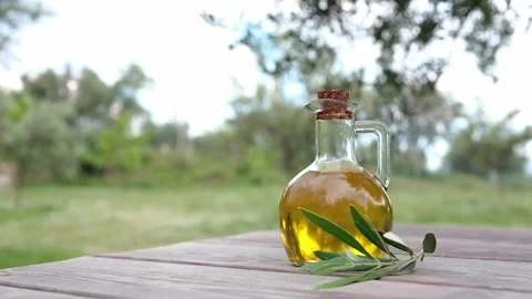 Bottle of extra virgin olive oil on a wooden table in an Olive Garden. Albania Stock Footage 242939483