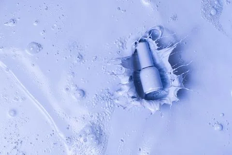 The bottle falls into the liquid paint Stock Photos