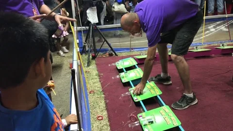 Bottle game instructor showing how to play the game at fair Stock-Footage 73430849
