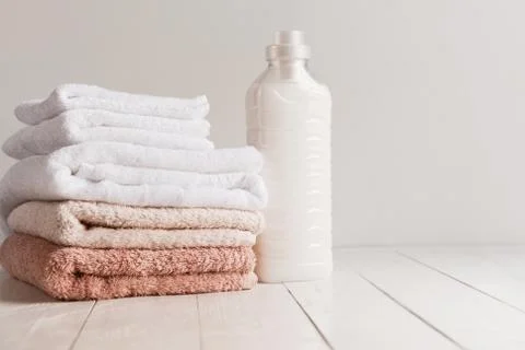 Bottle with gel for washing and a stack of fresh towels on a wooden table Stock Photos