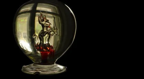A bottle with a glass figure of a devil with red elements inside. Halloween f Stock Photos