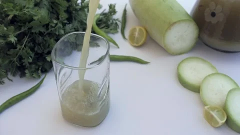 Bottle gourd drink with a slice of lemon is being poured in transparent glass... Stock Footage 155612968