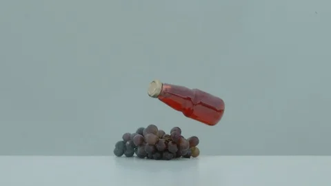 Bottle of grape juice falling on red grapes, Ultra Slow Motion Stock-Footage 86578489