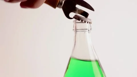 A bottle of green soda is opened with a can opener Stock Footage 134908373