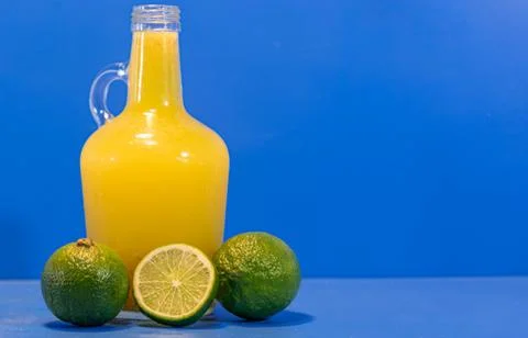 Bottle of lemonade and fresh lemon fruits on blue background Stock Photos