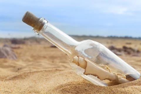 Bottle with a letter on the beach close-up Stock Photos