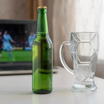 Bottle of light beer and empty beer glass mug on a white table. The backgroun Stock Photos