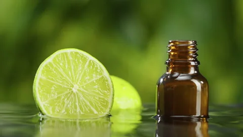 Bottle with lime in water close-up, lime juice. Making aroma serum on green Video stock 167044614