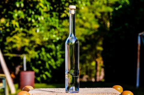 A bottle of liquor is sitting on a table in a backyard Foto stock