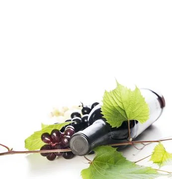 Bottle of luxury red wine and grape vine isolated over white background Stock-Fotos