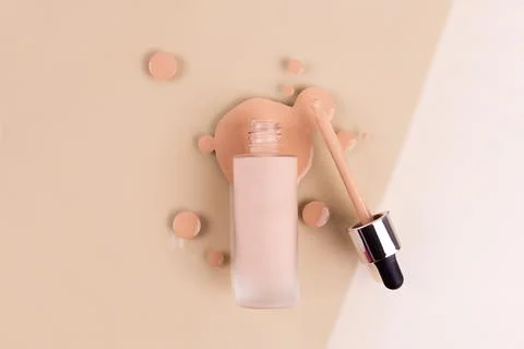 Bottle of makeup foundation and samples on beige background. Liquid foundat.. Stock Photos