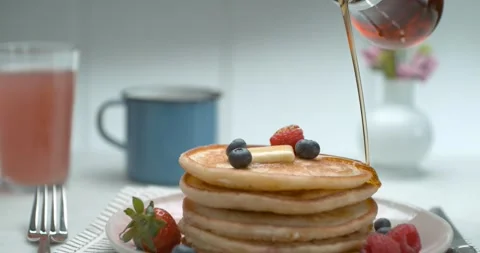 Bottle of maple syrup being poured over a stack of delicious plate of pancakes o Stock Footage 199458780