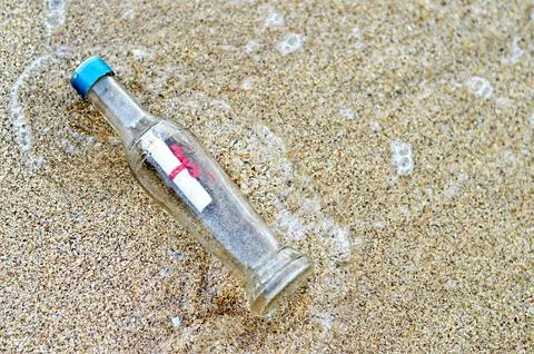 Bottle with message on sandy beach Foto stock