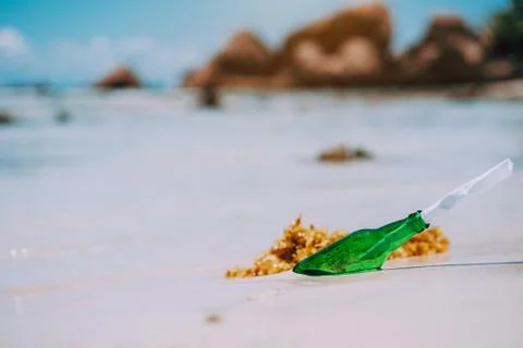 Bottle with message on white paradise sandy beach with blurred background Stock-Fotos