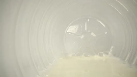 Bottle with milk bubbles and drops on a white background Video stock 146329526