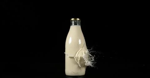Bottle of Milk Exploding against Black Background 写真素材