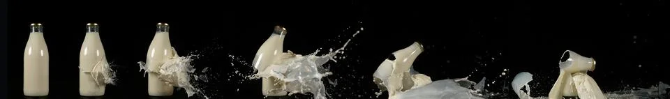 Bottle of Milk Exploding against Black Background. Stock Photos