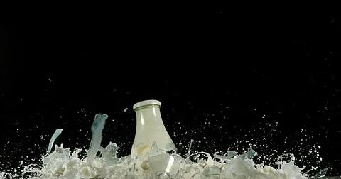 Bottle of Milk Exploding against Black Background 스톡 사진